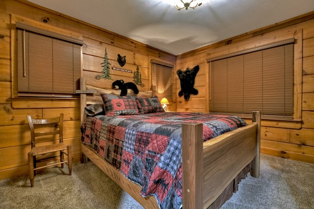 bedroom with wood walls, light colored carpet, and a textured ceiling