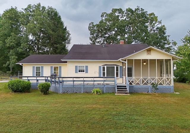 back of property featuring a wooden deck and a lawn