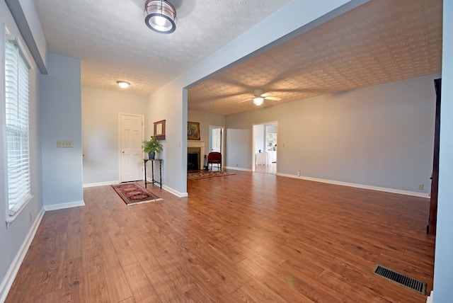 foyer with hardwood / wood-style floors, a textured ceiling, and ceiling fan