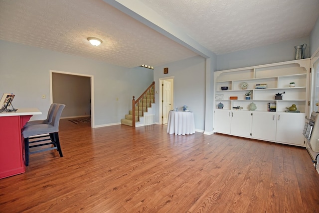 living room featuring a textured ceiling and light wood-type flooring