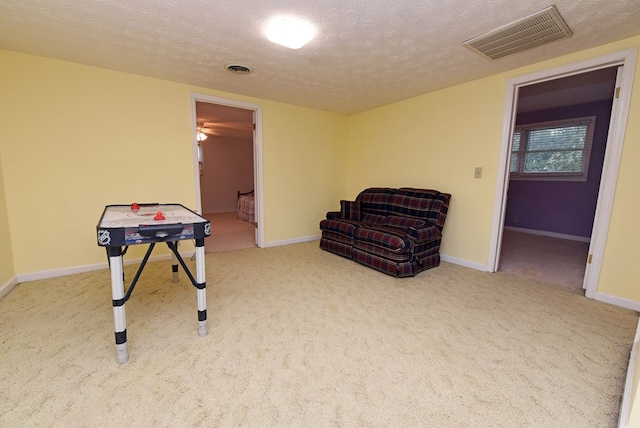 recreation room featuring carpet floors and a textured ceiling