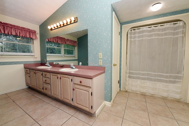 bathroom with tile patterned floors, lofted ceiling, a textured ceiling, and vanity