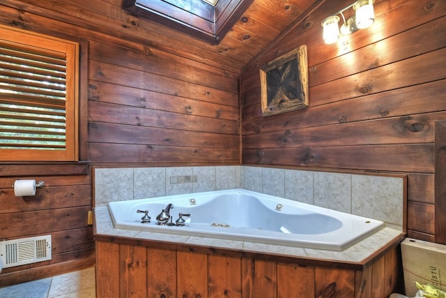 112 Songbird, Blue Ridge, GA 30513 - bathroom featuring a skylight, a jetted tub, vaulted ceiling, tile patterned floors, and wooden walls