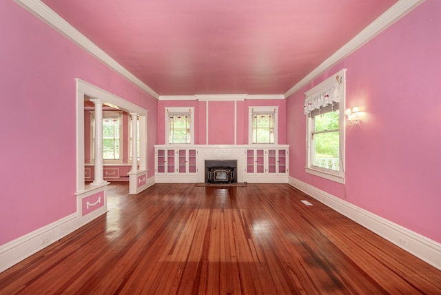 10 New Town St, Tate, GA 30177 - unfurnished living room featuring decorative columns, a wood stove, hardwood / wood-style flooring, ornamental molding, and baseboards