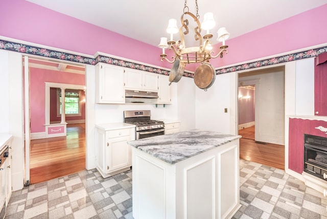 10 New Town St, Tate, GA 30177 - kitchen featuring stainless steel gas range, under cabinet range hood, a chandelier, and white cabinets