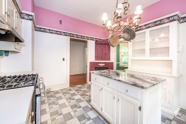 10 New Town St, Tate, GA 30177 - kitchen featuring stainless steel range with gas stovetop, a chandelier, under cabinet range hood, white cabinets, and light flooring