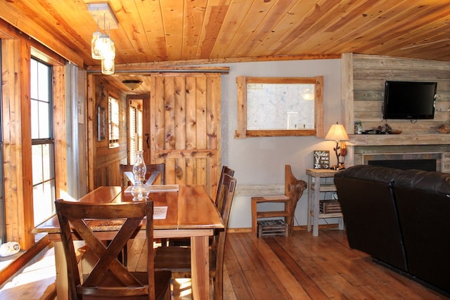 dining room with wood-type flooring, wood walls, and wood ceiling