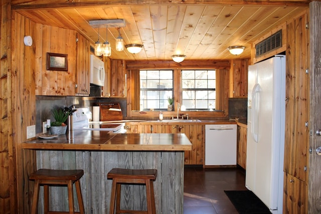 kitchen featuring wood walls, white appliances, wooden ceiling, decorative backsplash, and kitchen peninsula