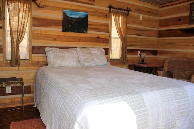 bedroom with wooden walls and dark hardwood / wood-style floors