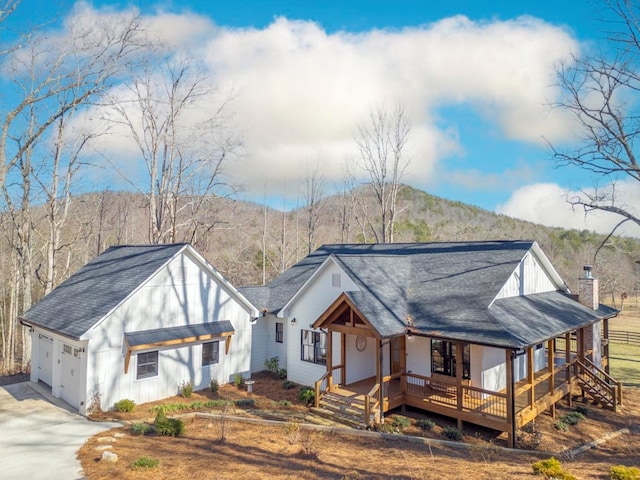 view of front of property featuring a garage, a mountain view, and covered porch