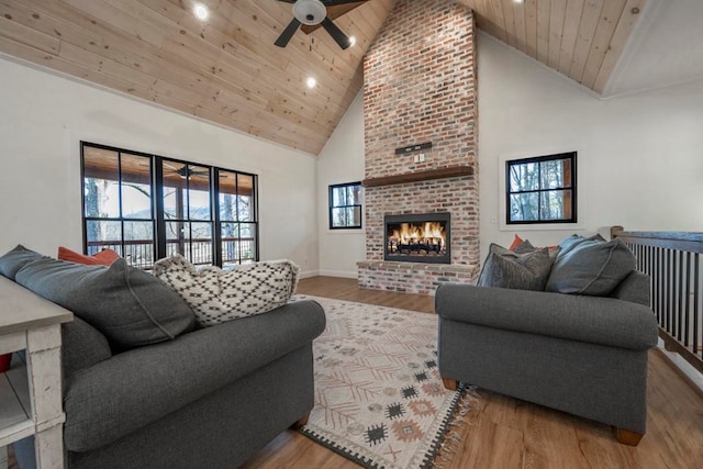 living room featuring wood-type flooring, a brick fireplace, wooden ceiling, and high vaulted ceiling