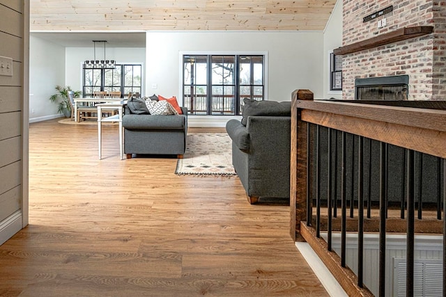 living room with lofted ceiling, a fireplace, hardwood / wood-style floors, and wooden ceiling