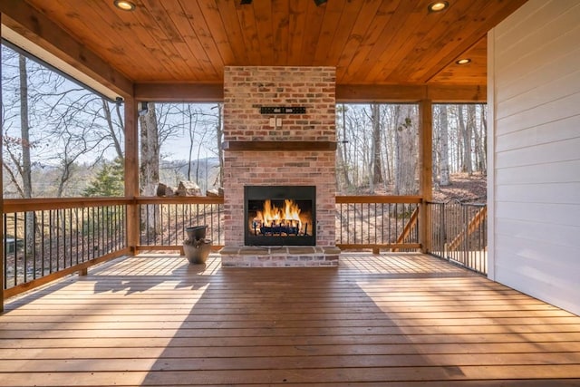 wooden terrace featuring an outdoor brick fireplace