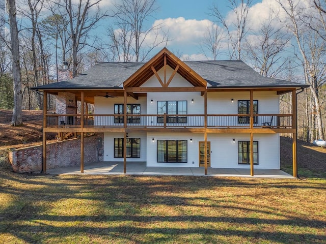 rear view of house featuring ceiling fan, a yard, and a patio area