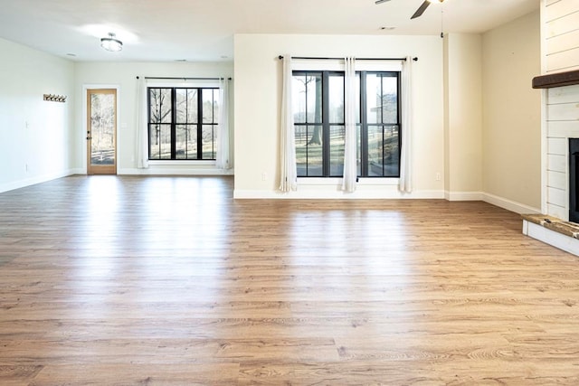 unfurnished living room with ceiling fan and light hardwood / wood-style floors