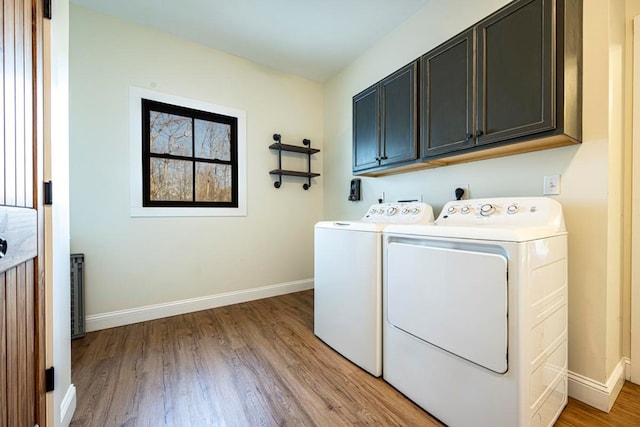 washroom with cabinets, washing machine and clothes dryer, and light wood-type flooring