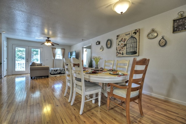 dining space with ceiling fan, light hardwood / wood-style flooring, french doors, and a textured ceiling