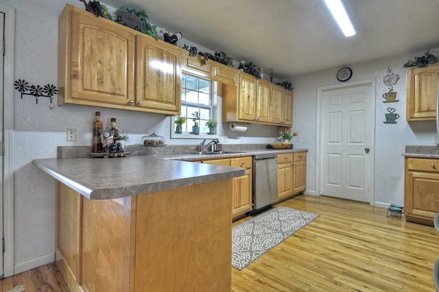 kitchen with dishwasher, sink, a breakfast bar area, kitchen peninsula, and light wood-type flooring