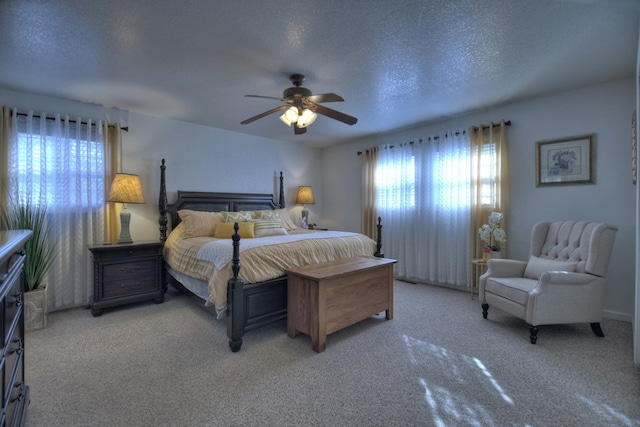 carpeted bedroom featuring a textured ceiling and ceiling fan