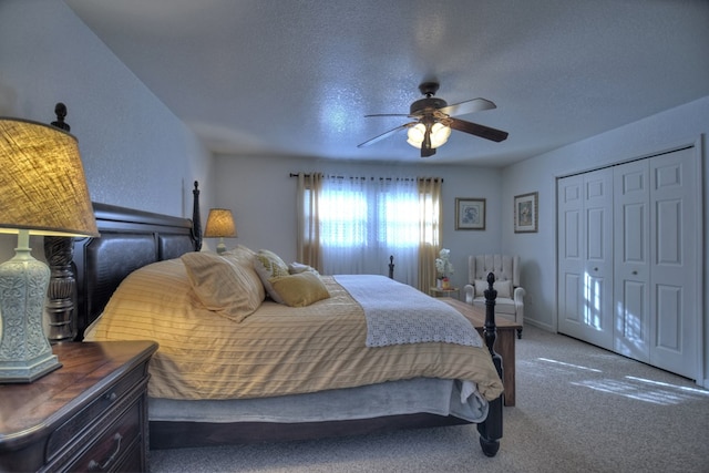 carpeted bedroom featuring ceiling fan, a closet, and a textured ceiling