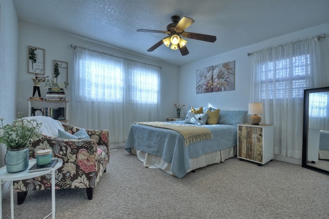 carpeted bedroom featuring a textured ceiling and ceiling fan