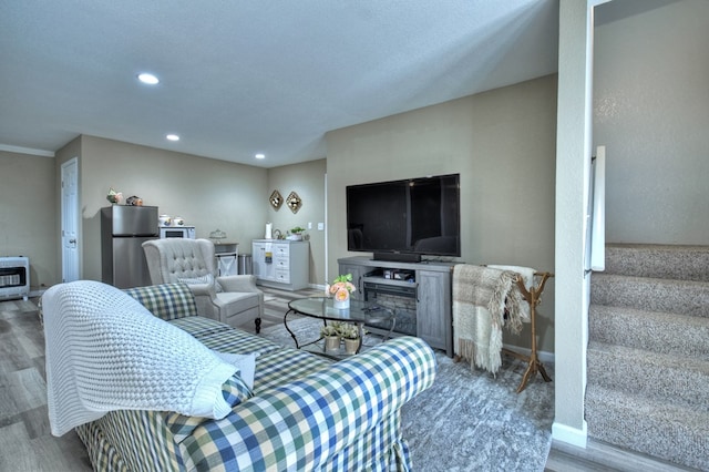 living room with heating unit and hardwood / wood-style floors