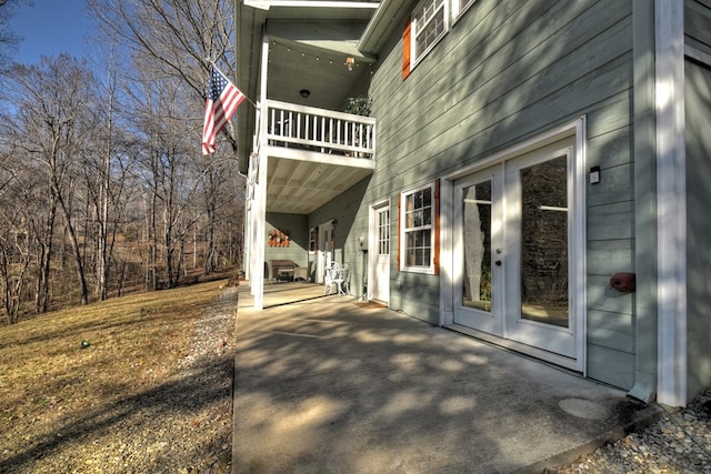 view of home's exterior with french doors, a balcony, and a patio