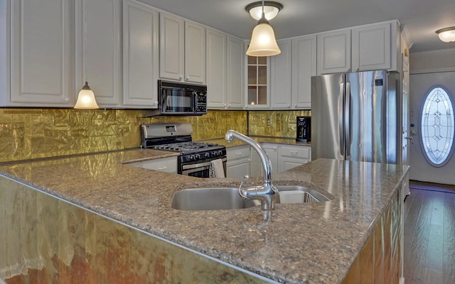 kitchen featuring pendant lighting, white cabinets, sink, light stone counters, and stainless steel appliances