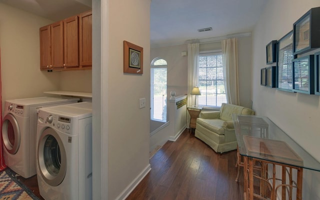 laundry area featuring cabinets, dark hardwood / wood-style floors, washing machine and dryer, and crown molding