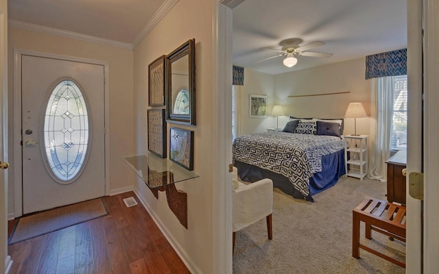 foyer entrance with hardwood / wood-style flooring, ceiling fan, a healthy amount of sunlight, and ornamental molding