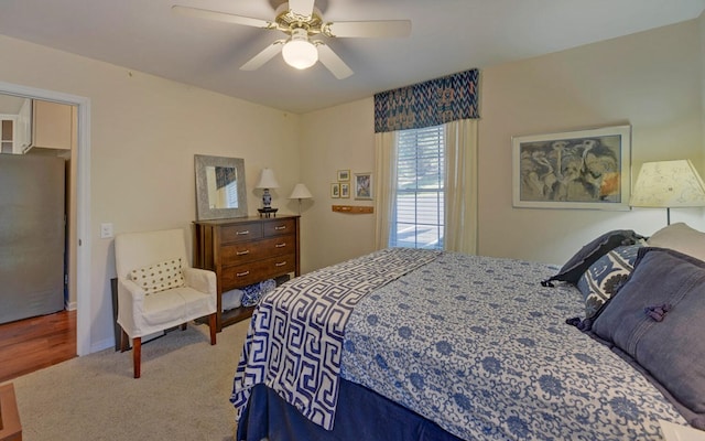 bedroom with stainless steel refrigerator, ceiling fan, and hardwood / wood-style flooring