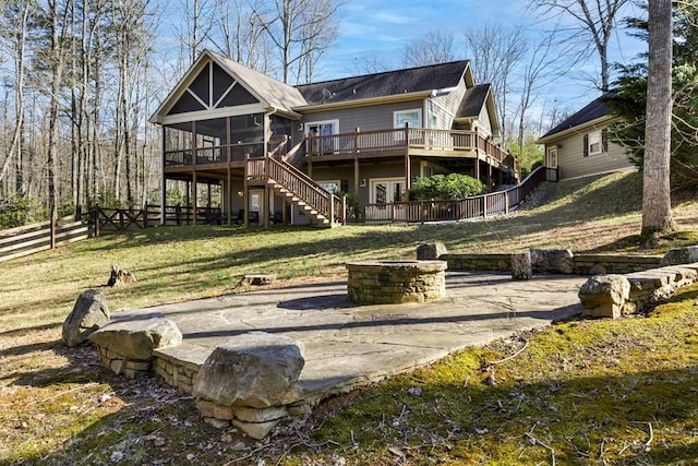 rear view of house with a yard, a sunroom, and a deck