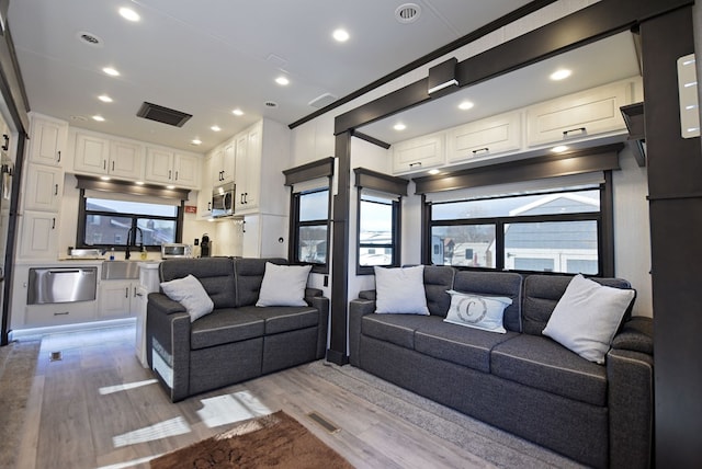 living room with sink and light hardwood / wood-style flooring