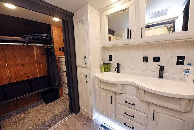 bathroom featuring vanity, backsplash, and hardwood / wood-style flooring