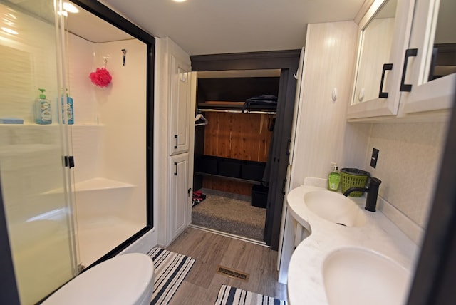 bathroom featuring a shower with shower door, wood-type flooring, and vanity