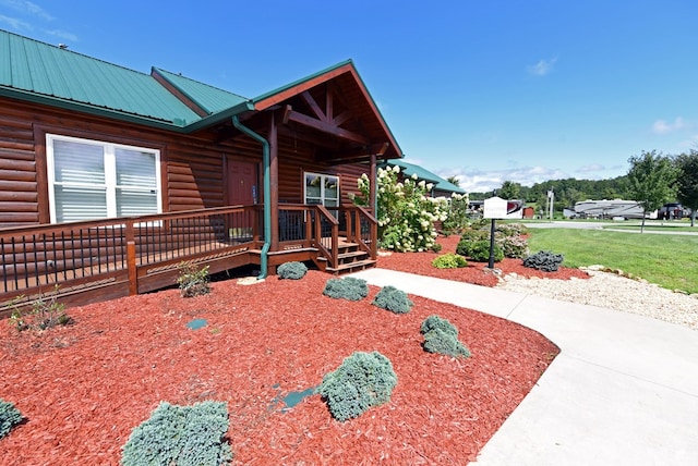 view of side of home featuring a lawn and covered porch