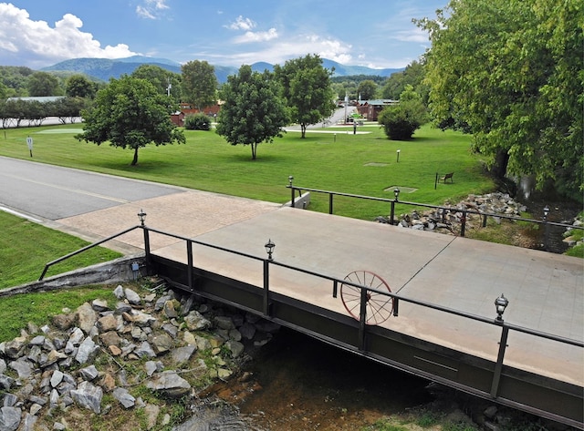 view of property's community with a lawn and a mountain view