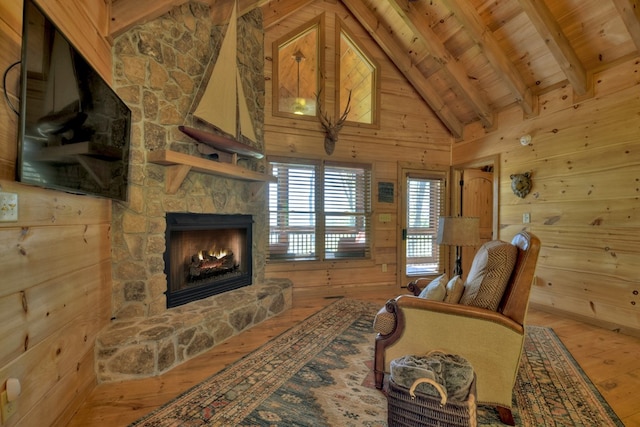 783 Moreland Dr N, Cherry Log, GA 30522 - living room with a stone fireplace, lofted ceiling with beams, wooden walls, wooden ceiling, and light wood-type flooring