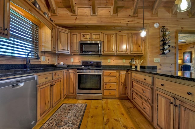 783 Moreland Dr N, Cherry Log, GA 30522 - kitchen with decorative light fixtures, appliances with stainless steel finishes, light hardwood / wood-style floors, beam ceiling, and wooden walls