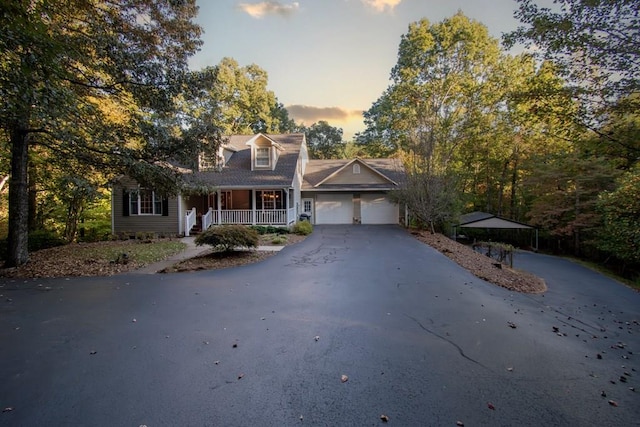 new england style home featuring a garage and a porch