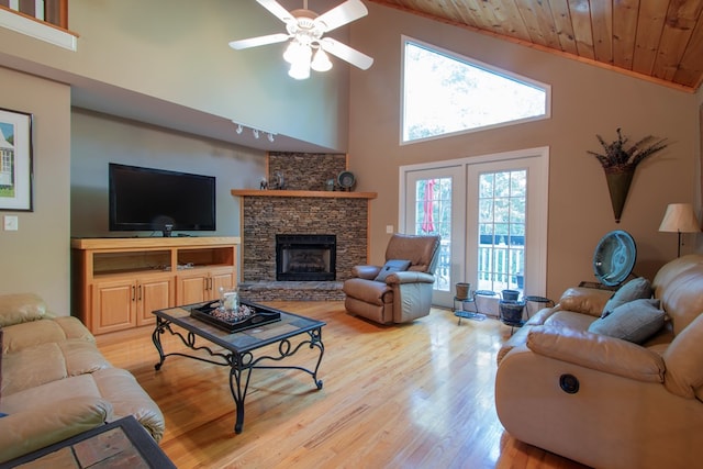 living room with wooden ceiling, ceiling fan, a fireplace, high vaulted ceiling, and light hardwood / wood-style flooring