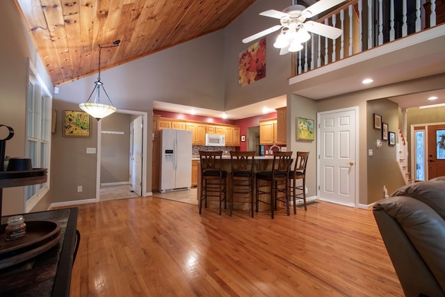 dining room with ceiling fan, wood ceiling, light hardwood / wood-style flooring, and high vaulted ceiling