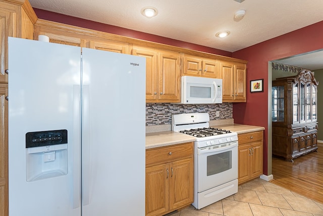 425 Tarheel Dr W, Murphy, NC 28906 - kitchen with tasteful backsplash, light tile patterned floors, light countertops, and white appliances