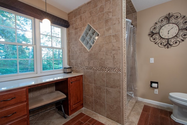 bathroom with curtained shower, toilet, and tile patterned flooring