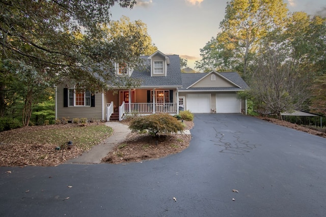 cape cod home with a garage and covered porch