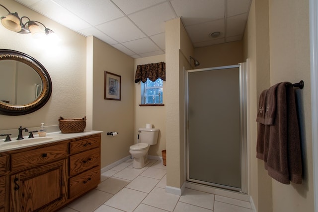 bathroom with tile patterned floors, an enclosed shower, vanity, and a drop ceiling