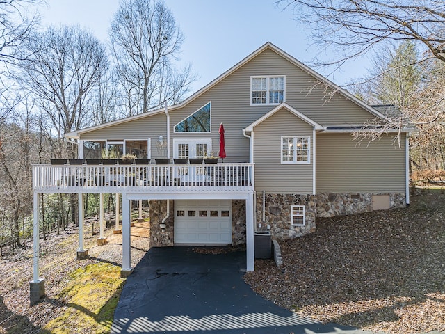 425 Tarheel Dr W, Murphy, NC 28906 - view of front facade with central AC, a deck, an attached garage, stone siding, and driveway