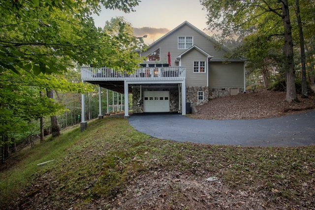 view of front of property featuring cooling unit, a deck, and a garage