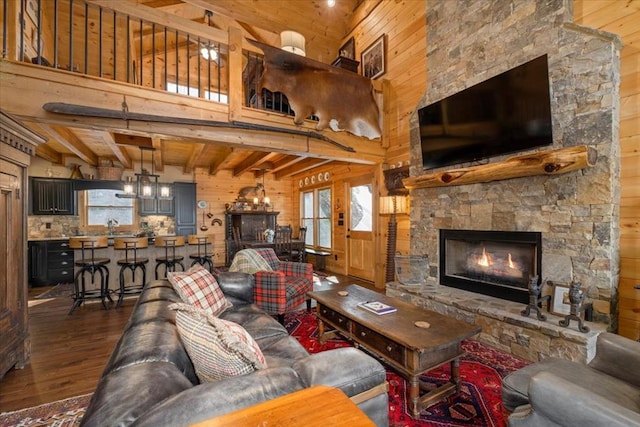 510 Gallery Ct, Ellijay, GA 30540 - living area with wood walls, dark wood-style flooring, healthy amount of natural light, a stone fireplace, and a wooden ceiling with exposed beams