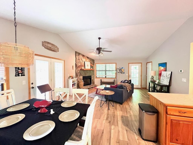 384 Shadow Pines Dr, Murphy, NC 28906 - dining area featuring lofted ceiling, light wood-style flooring, a ceiling fan, a fireplace, and french doors